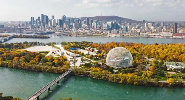 Aerial view of Montreal with the Biosphere and city skyline, surrounded by colourful autumn foliage and the St. Lawrence River