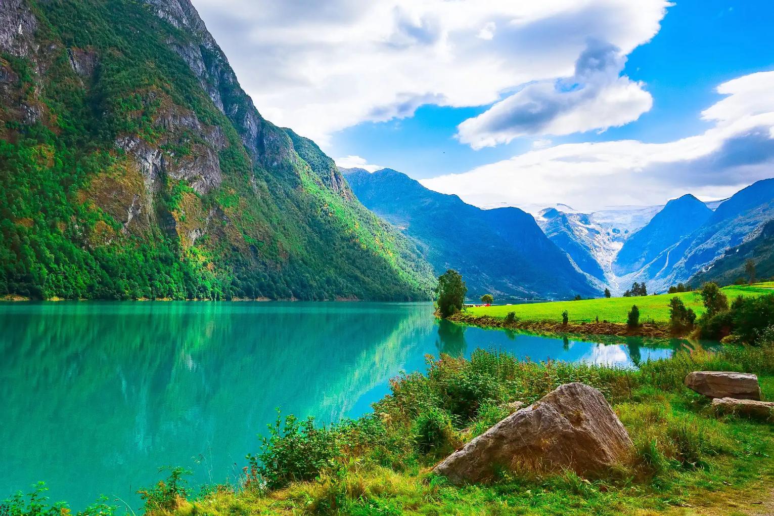 A scenic view of Sognefjord, Norway, featuring deep blue fjord waters surrounded by steep, green mountains
