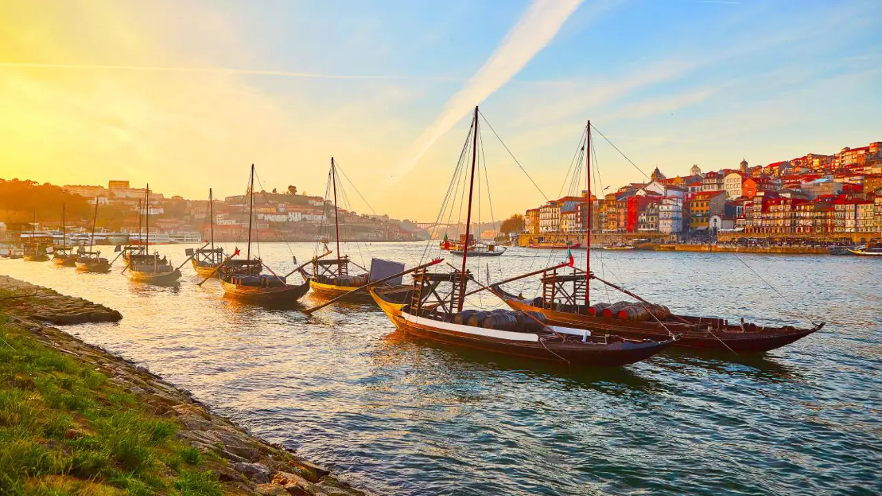 Traditional Wooden Boats, Called Barcos Rabelos Transporting Wine Barrels On The River Douro