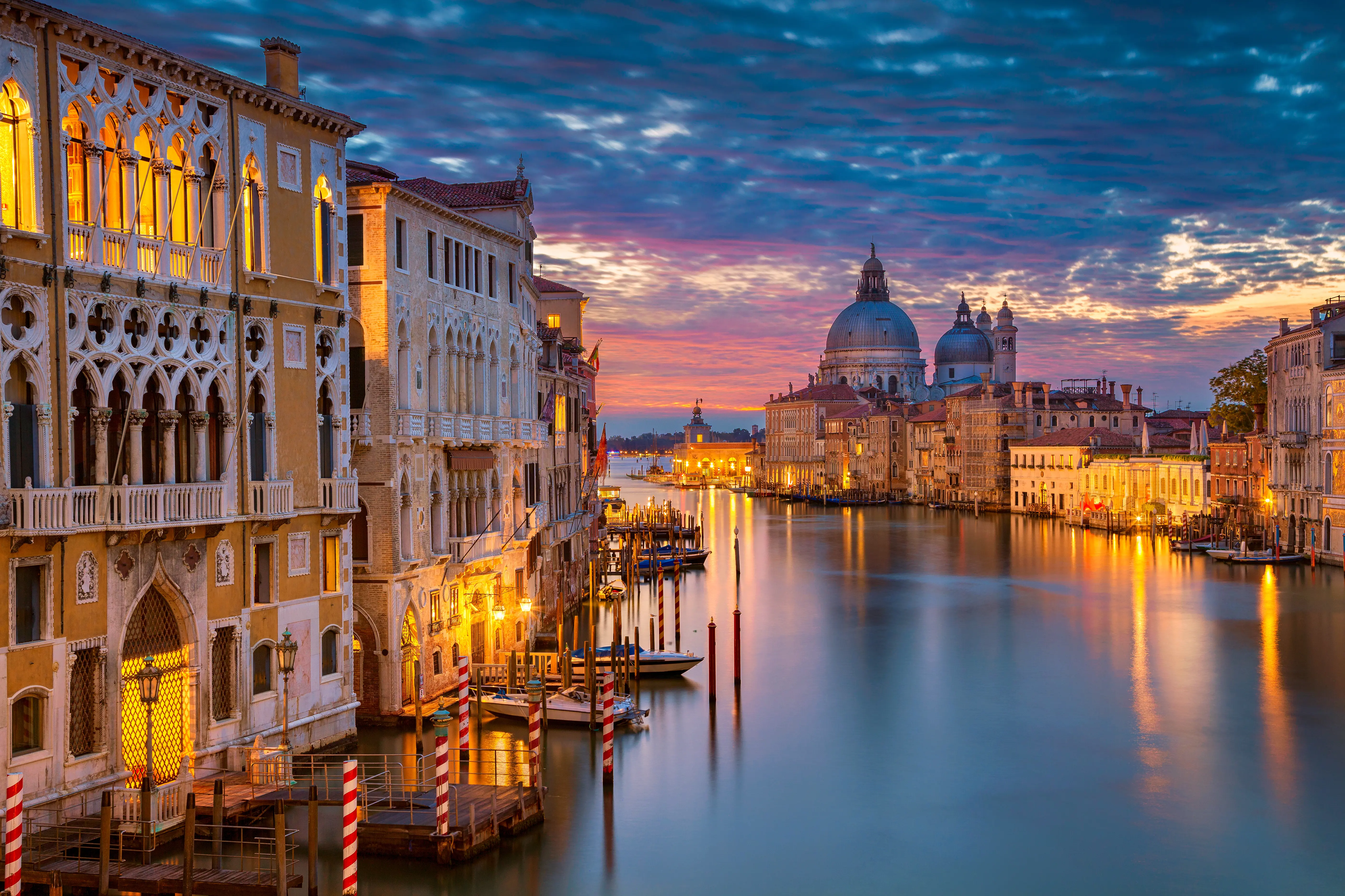 View of Venice at sunset, showing the Salute Church and a canal leading out to sea