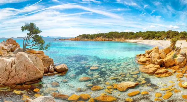 Costa Smeralda seascape, Sardinia, showing the clear blue water and rocks in the forefront