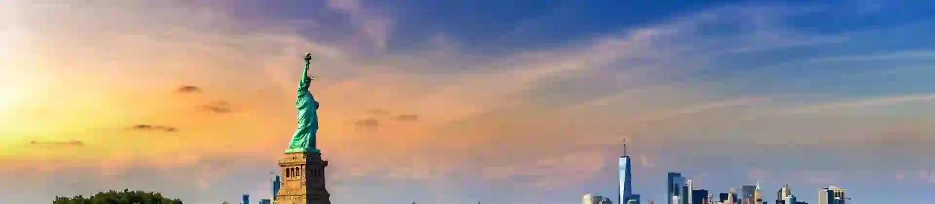 The Statue of Liberty standing on Liberty Island with Lower Manhattan’s skyline visible in the background across the water