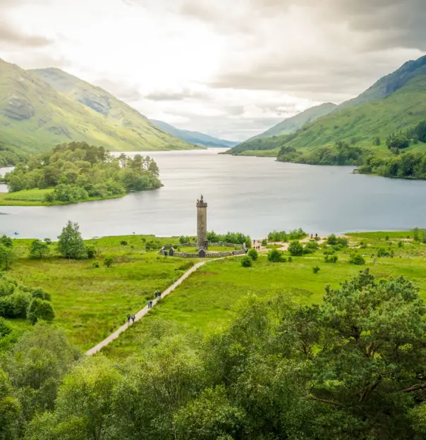 Zoomed out image of Glenfinnan Monument, with the view of Loch Shiel and the surrounding mountains