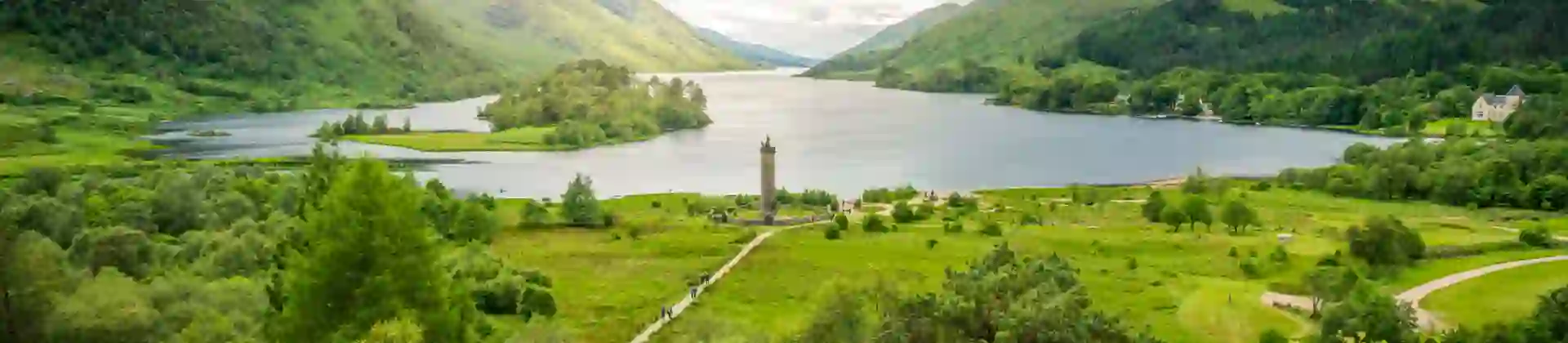 Zoomed out image of Glenfinnan Monument, with the view of Loch Shiel and the surrounding mountains