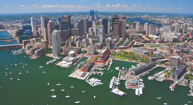 Aerial view of Boston's city skyline and harbour with moored boats