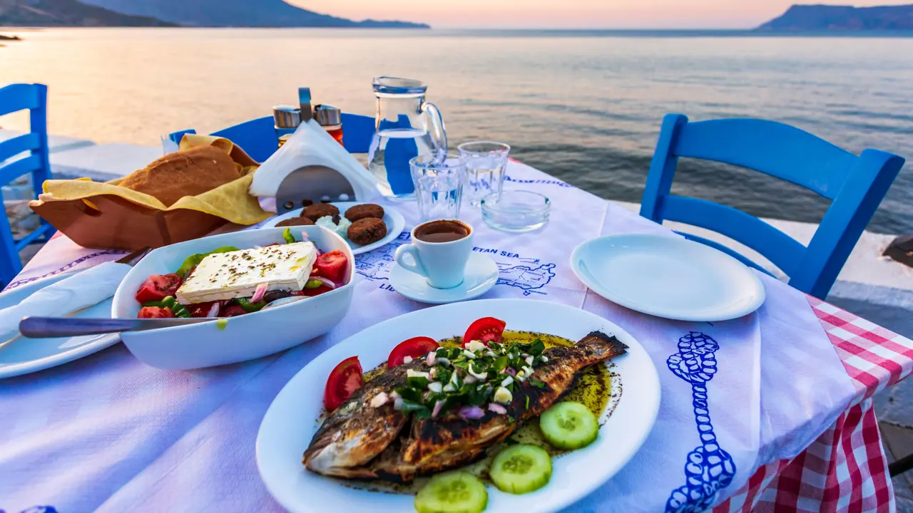 Dinner laid with traditional Cretan Dorada fish with Greek salad, with a view of the sea.