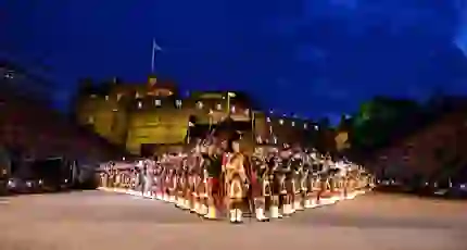 The Royal Edinburgh Military Tattoo lined up in formation infront of Edinburgh castle night time