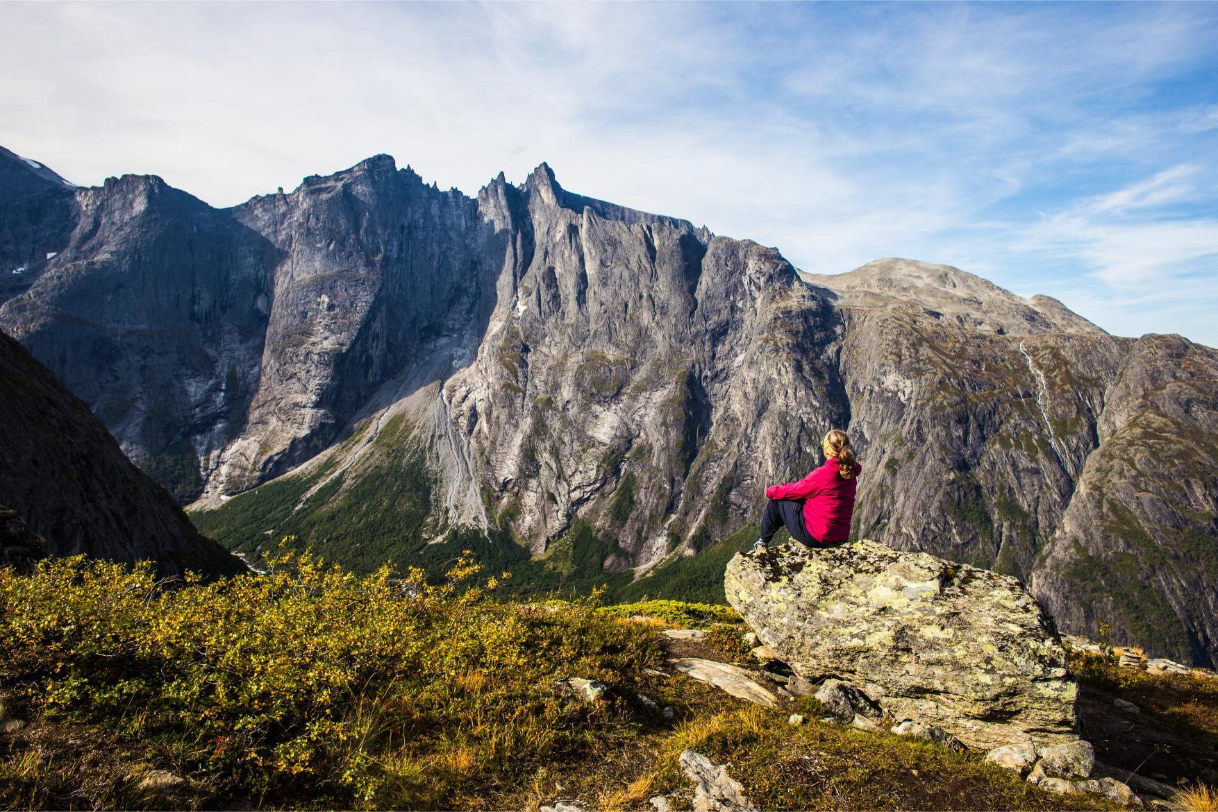 Solo woman traveller enjoying the views of the famous Troll Wall, Fjord Norway