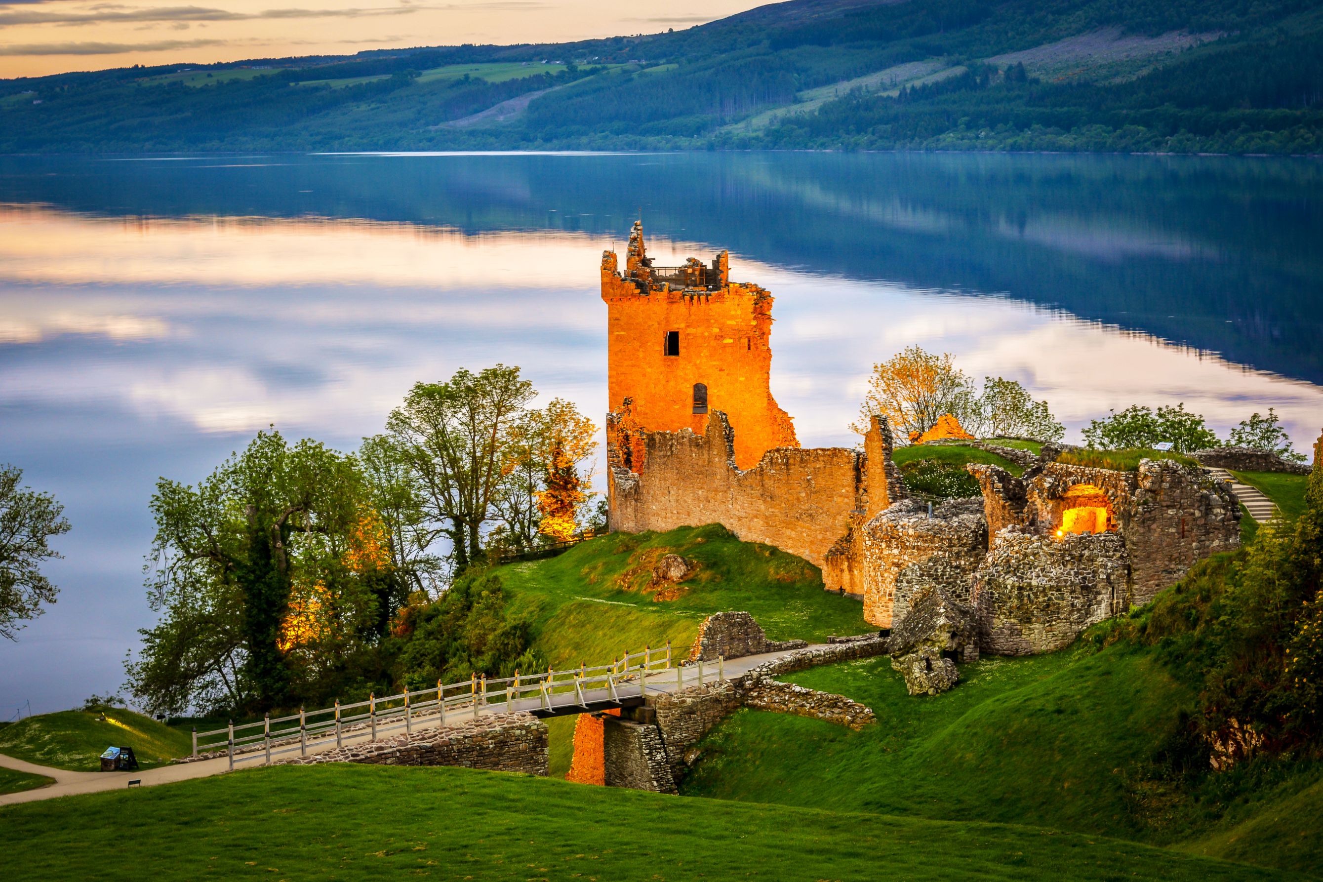 View of Urquhart Castle and Loch Ness, with the sun shining on the castle