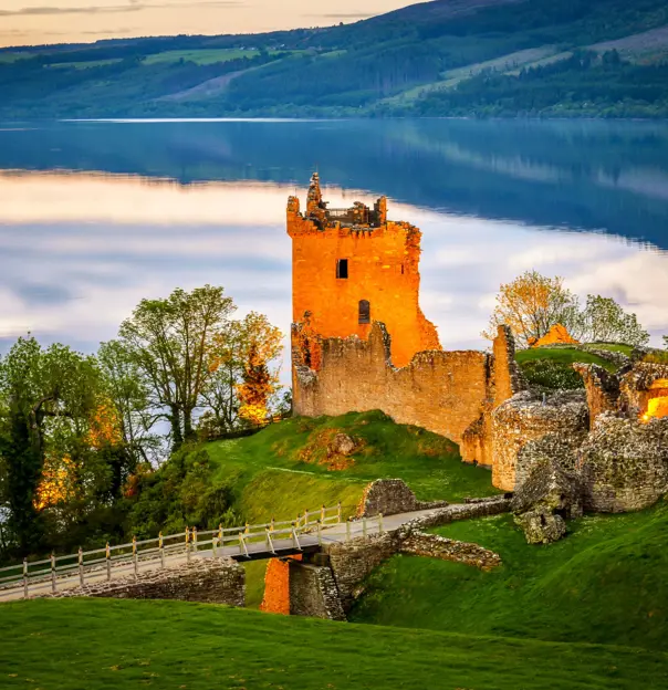 View of Urquhart Castle and Loch Ness, with the sun shining on the castle