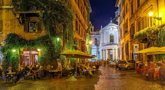 Streets of Rome at night, with people dining al fresco