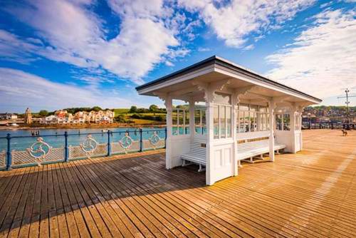 Golden light drenches the classic pier of Swanage, Dorset.