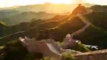 The Great Wall winding over green mountains at sunset, Beijing, China