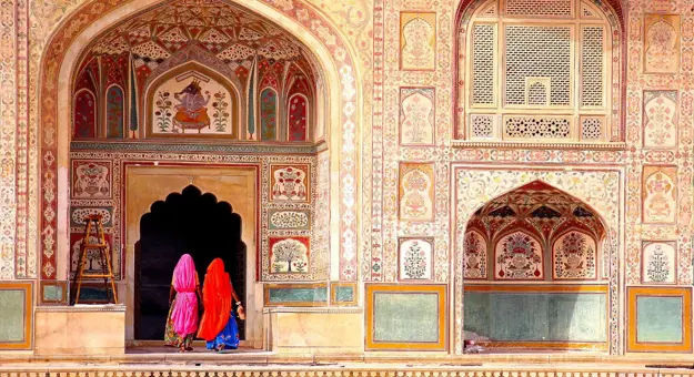 Entrance door of Amber Fort in India, showcasing intricate carvings and traditional Mughal-style sandstone architecture