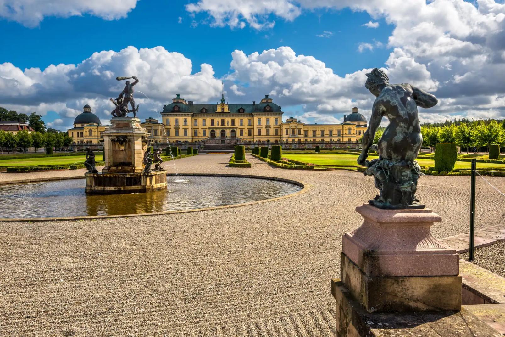 Drottningholm Palace in Sweden, with a central fountain, statues, and formal gardens in front