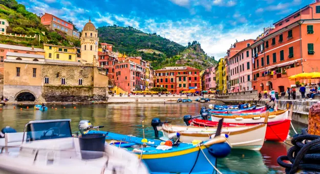 A row of canoes on the water infront of the town of Clinque Terre in Liguria, Italy