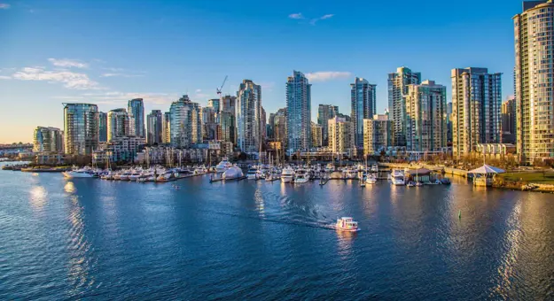 Aerial view of Vancouver Harbour, showing modern high-rise buildings along the waterfront and boats in the harbour