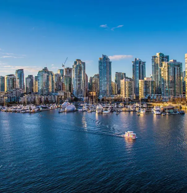 Aerial view of Vancouver Harbour, showing modern high-rise buildings along the waterfront and boats in the harbour