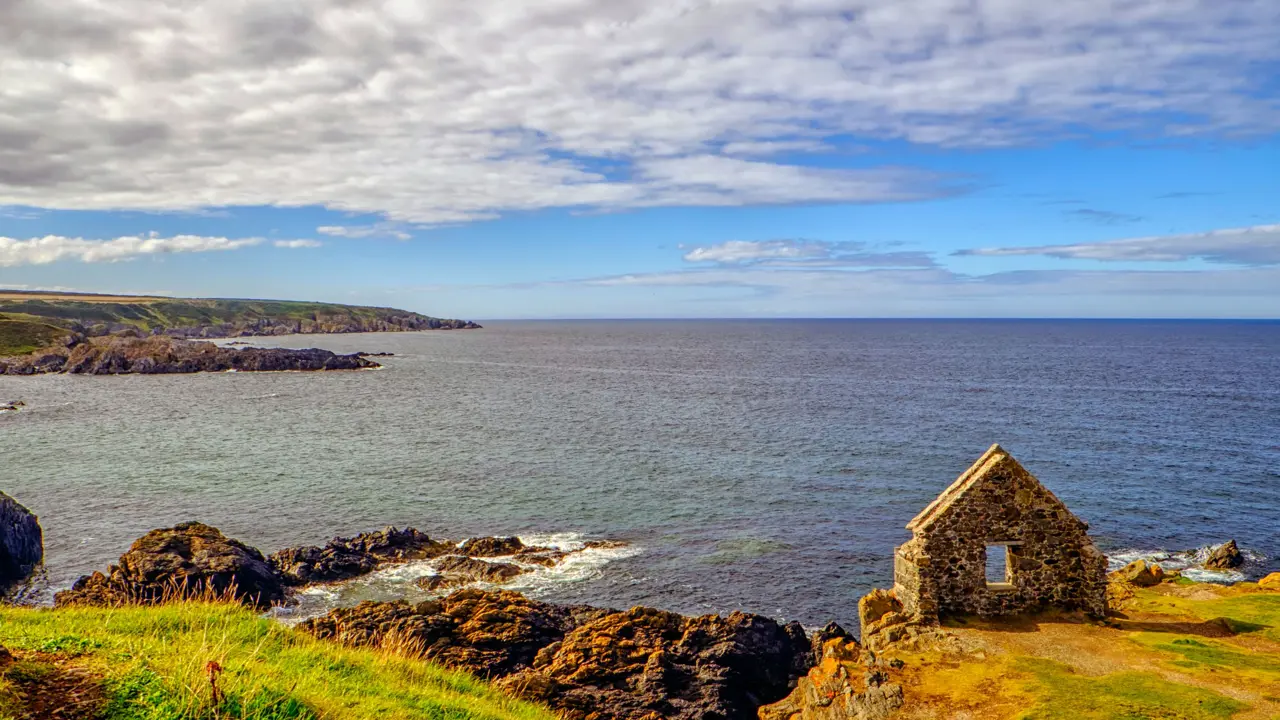 View of Moray Firth inlet, with grass and ruins of a building in the forefront