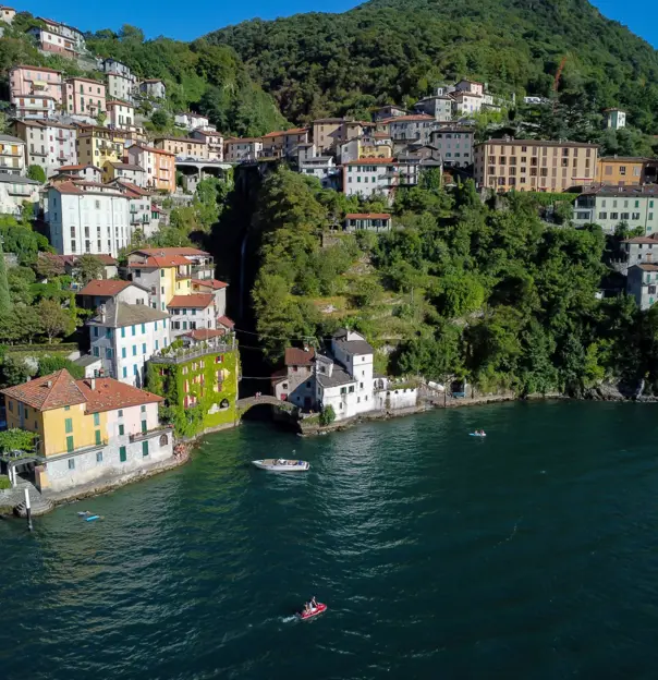 View of Nesso's waterfront, showing buildings up the mountain and boats on the water