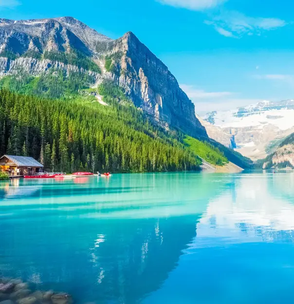 Turquoise waters of Lake Louise surrounded by forested slopes and snow-capped mountains