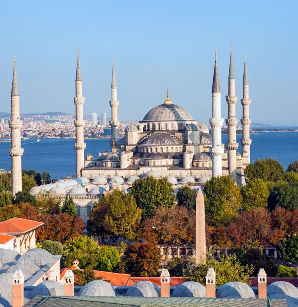 Exterior view of the Blue Mosque in Istanbul, Turkey, showing its domes and six minarets against a clear sky