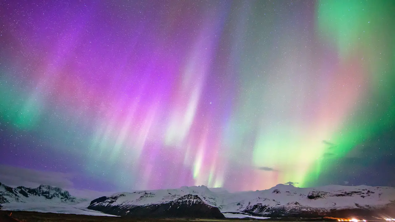 Purple Northern Lights with hints of green, and snowy land below