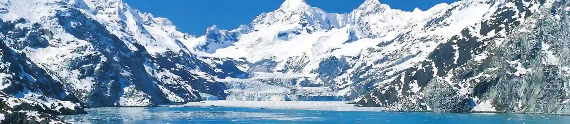The MS Koningsdam cruise ship sailing through Glacier Bay, surrounded by calm icy waters and dramatic snow-capped mountains