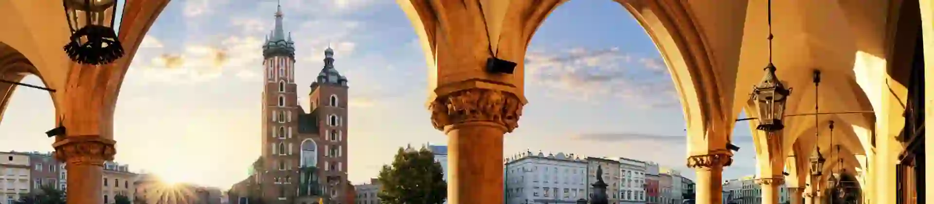 View of St. Mary's Basilica from the arches of the Cloth Hall in Kraków’s main square at sunrise