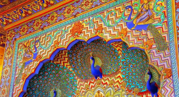 Ornate Peacock Gate at Jaipur City Palace, India, featuring intricate colourful artwork and detailed carvings inspired by peacock feathers and traditional Rajasthani design