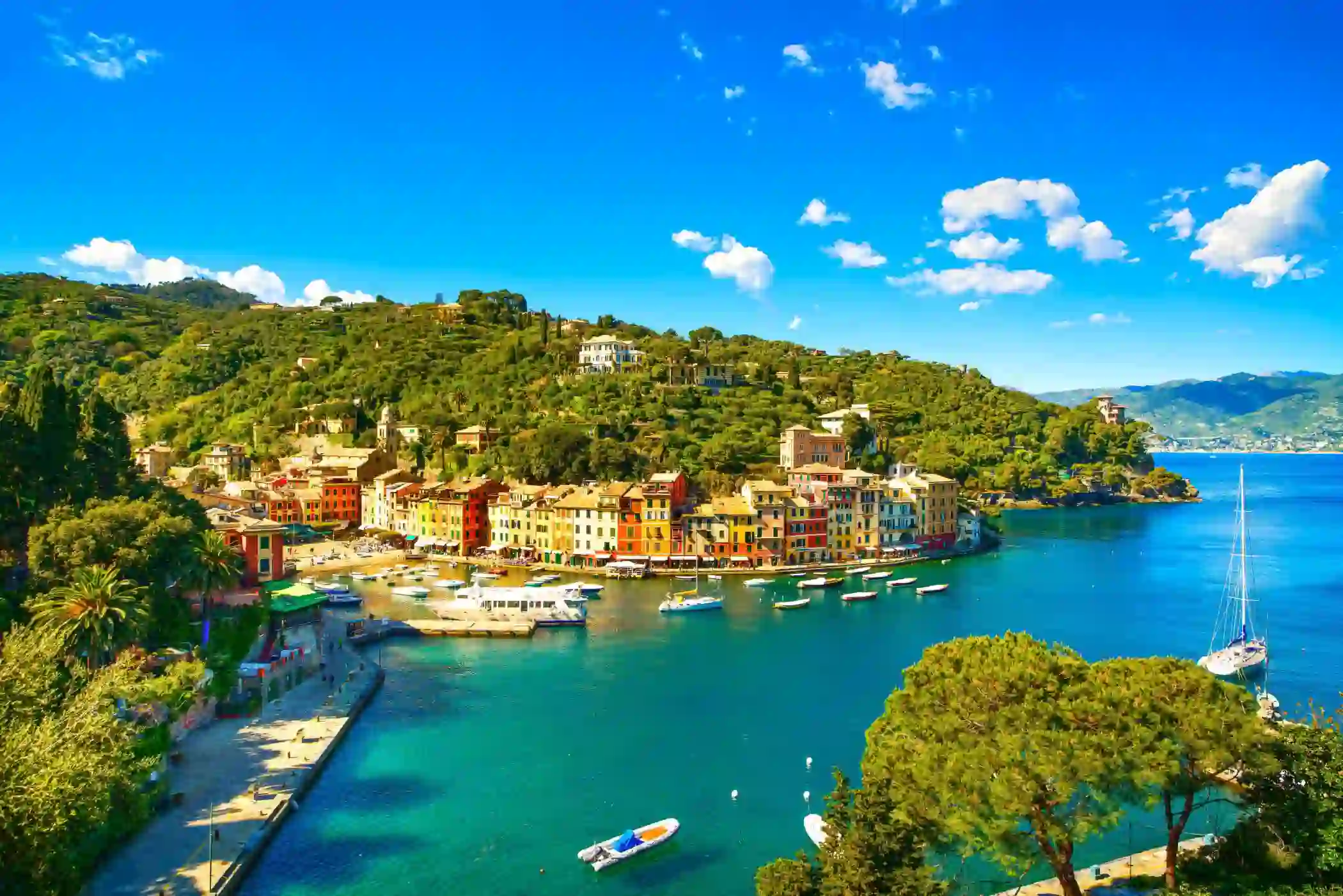 View of a small beach in Portofino, showing boats on the water and buildings on the waterfront