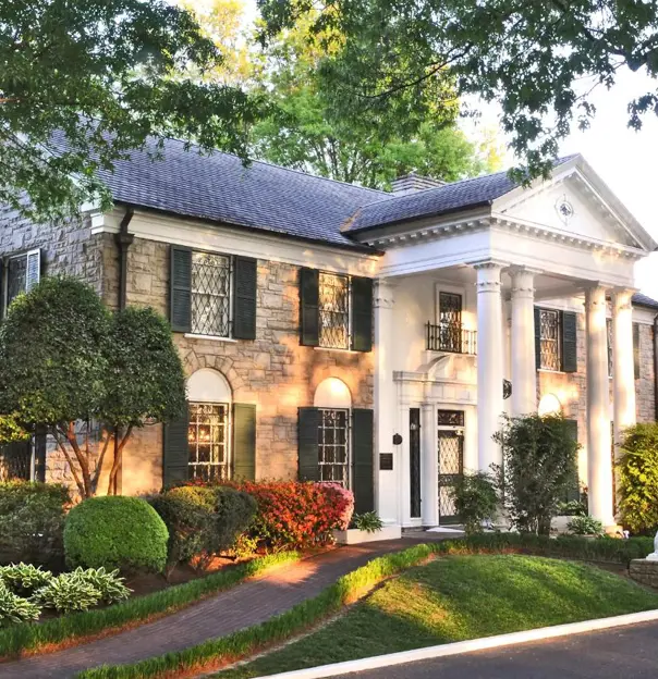 Graceland mansion in Memphis, Tennessee, the former home of Elvis Presley, featuring a grand white-columned façade surrounded by well-kept lawns and tall trees