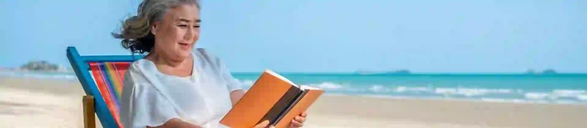 Woman Reading Book on Beach