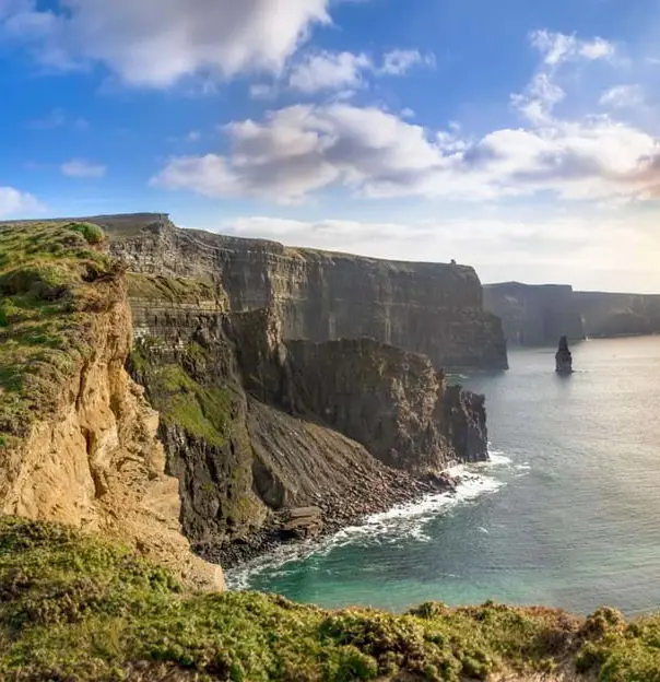 Cliffs of Moher, view of the sea on the right and rassy land in the left forefront