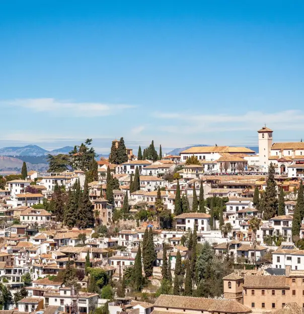Traditional whitewashed houses on a hillside in a sunlit Andalucían village