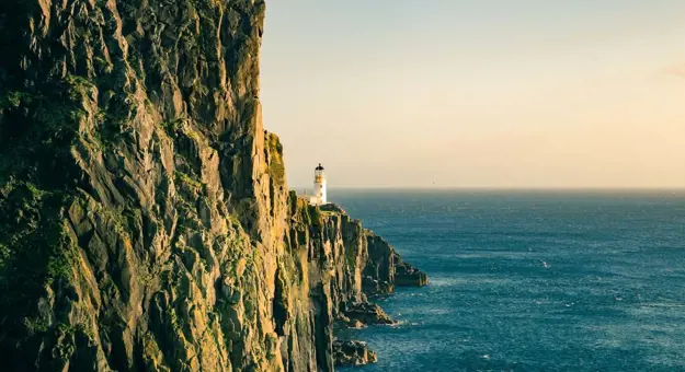 Lighthouse on the edge of a cliff, and the sea that it looks out on 