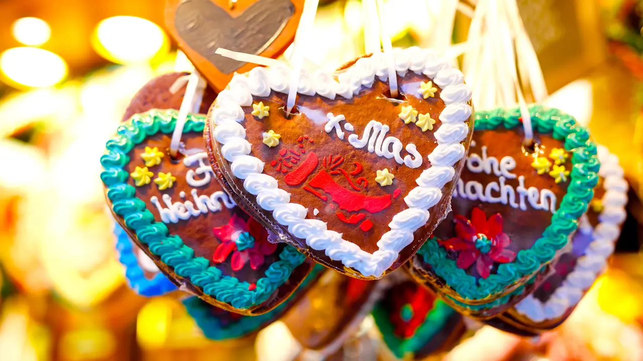 Close up of heart shaped, chocolate Christmas treats hanging on some string. 