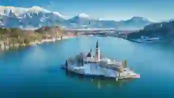 Lake Bled in winter with its island church in the centre and frosty mountains in the background