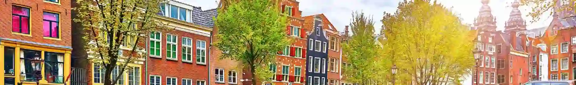 Scenic view of a canal in Amsterdam, Netherlands, with traditional Dutch buildings lining both sides