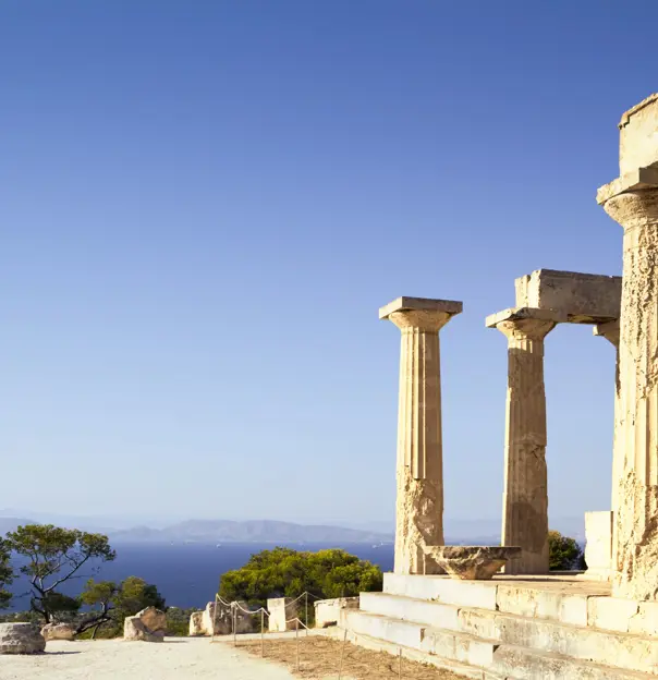 Ruins of a temple on a hill, with view of mountains in the distance